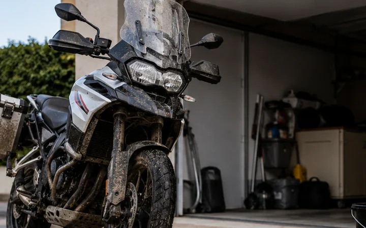 Moto sporca dopo un giro ferma davanti al garage